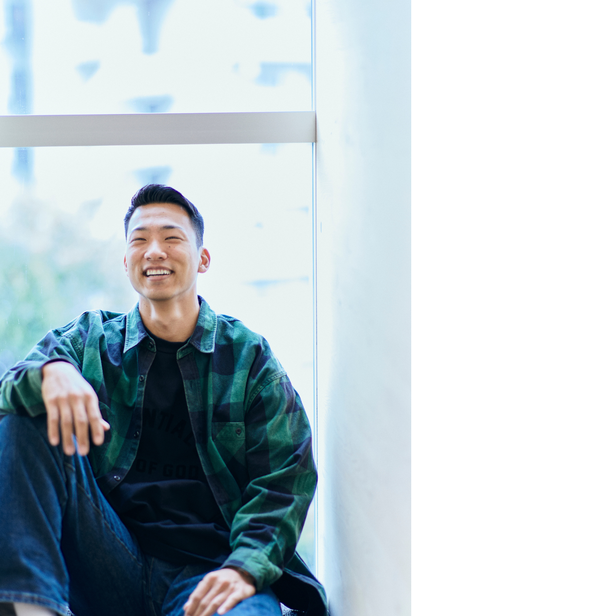 The photo of Maruyama leaning against the window with his right leg bent and smiling.